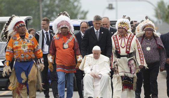 Pope Francis is wheeled beside Indigenous chiefs after visiting the Ermineskin Cree Nation Cemetery in Maskwacis, Alberta, during his papal visit across Canada on Monday, July 25, 2022. (Nathan Denette/The Canadian Press via AP)