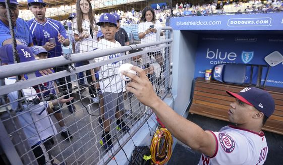 Washington Nationals&#39; Juan Soto signs autographs for fans prior to a baseball game against the Los Angeles Dodgers Tuesday, July 26, 2022, in Los Angeles. (AP Photo/Mark J. Terrill)