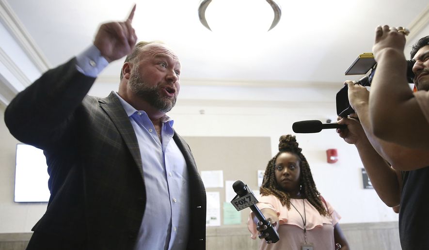 Alex Jones talks to media during a midday break during the trail at the Travis County Courthouse in Austin, Texas, Tuesday, July 26, 2022. (Briana Sanchez/Austin American-Statesman via AP, Pool)
