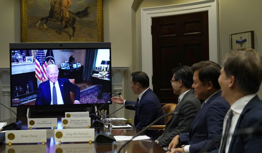 President Joe Biden, on screen at left, listens as SK Group Chairman Chey Tae-won, center, speaks from the Roosevelt Room of the White House in Washington, Tuesday, July 26, 2022. The meeting comes as the Biden administration is seeking the cooperation of Asian allies such as South Korea to reinforce supply chains for critical components such as semiconductors. (AP Photo/Susan Walsh)