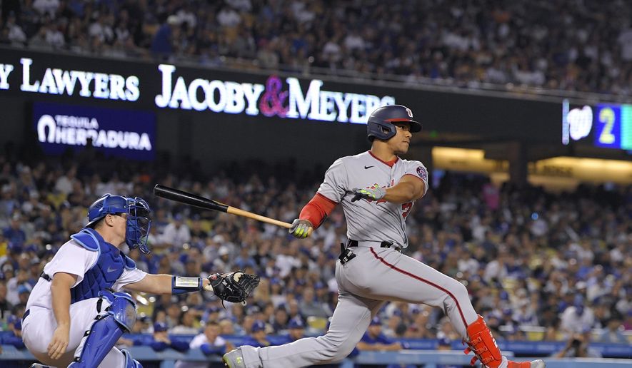 Washington Nationals&#39; Juan Soto, right, hits a two RBI triple as Los Angeles Dodgers catcher Will Smith watches during the fifth inning of a baseball game Monday, July 25, 2022, in Los Angeles. (AP Photo/Mark J. Terrill)