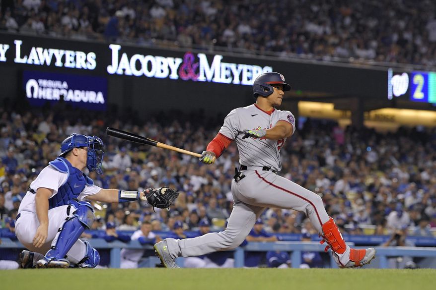 Washington Nationals&#39; Juan Soto, right, hits a two RBI triple as Los Angeles Dodgers catcher Will Smith watches during the fifth inning of a baseball game Monday, July 25, 2022, in Los Angeles. (AP Photo/Mark J. Terrill)