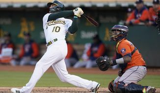 Oakland Athletics&#39; Chad Pinder (10) watches his grand slam in front of Houston Astros catcher Martin Maldonado during the third inning of a baseball game in Oakland, Calif., Tuesday, July 26, 2022. (AP Photo/Jeff Chiu)