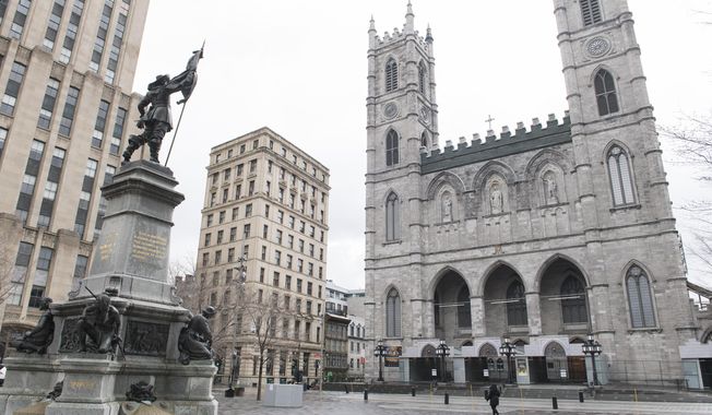 A woman walks by Notre-Dame Basilica in Montreal, on April 10, 2020. Pope Francis arrives in Quebec on Wednesday, July 27, 2022, at a time when many French Canadians in the province are not only moving away from religion but explicitly rejecting it, embracing secularization long after their forebears built their identify on the rock of the Catholic Church. (Graham Hughes/The Canadian Press via AP, File)