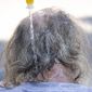 Maggy Johnston, ARCHES outreach coordinator, squeezes water on a man&#39;s head during a heat wave with temperatures reaching 100 degrees in Salem, Ore., Tuesday, July 26, 2022. (Brian Hayes/Statesman-Journal via AP)