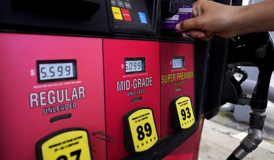 A customer holds a credit card at the pay-at-the-pump gasoline pump in Rolling Meadow, Ill., Thursday, June 30, 2022. (AP Photo/Nam Y. Huh) **FILE**