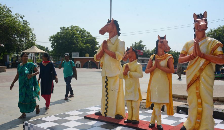 Pedestrians walk past the mascot, Thambi, displayed near Marina beach  on the inaugural day of the 44th Chess Olympiad in Chennai, India, Thursday, July 28, 2022. The Olympiad will run from July 28 to Aug. 10 at Poonjeri village in Mamallapuram. (AP Photo)