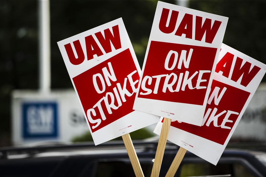 Signs are posted during a demonstration outside a General Motors facility in Langhorne, Pa., Sept. 16, 2019. The United Auto Workers union is increasing the strike pay it offers workers who walk off the job for the second time this year in 2022, following a spate of strikes amid the ongoing worker shortages nationwide. (AP Photo/Matt Rourke, File)