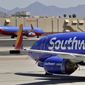 Southwest Airlines jets are stored at Sky Harbor International Airport in Phoenix, Tuesday, April 28, 2020. (AP Photo/Matt York, File)