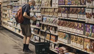 A man shops at a supermarket on Wednesday, July 27, 2022, in New York. The U.S. economy shrank from April through June for a second straight quarter, contracting at a 0.9% annual pace and raising fears that the nation may be approaching a recession.    (AP Photo/Andres Kudacki)