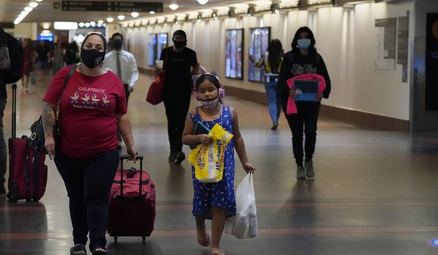 Travelers wear masks inside Union Station Thursday, July 28, 2022, in Los Angeles. Health officials in Los Angeles County are debating a decision to reinstate an indoor mask mandate Thursday. (AP Photo/Marcio Jose Sanchez)