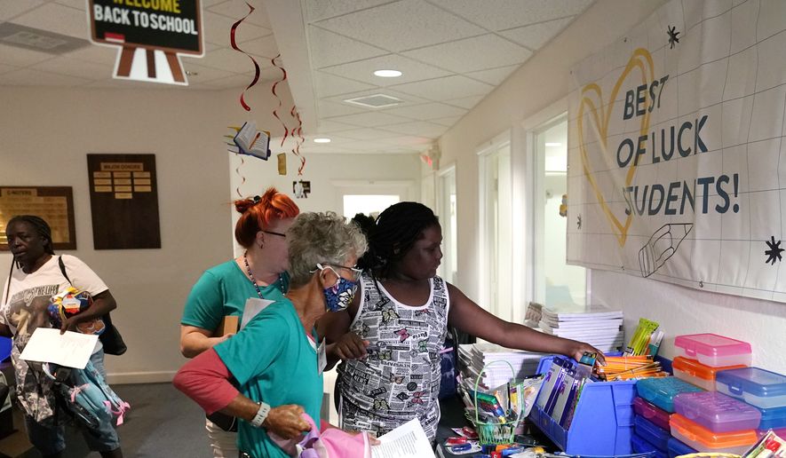 Aaliyah Floyd, 10, right, selects school supplies with volunteer Cindy Blomquist, left, at the annual Back to School Distribution Day at The Pantry, Friday, July 29, 2022, in Fort Lauderdale, Fla. The Pantry works with grandparents who are the primary caregivers for their grandchildren, offering free backpacks, lunch boxes, school supplies and sneakers. (AP Photo/Lynne Sladky) ** FILE **
