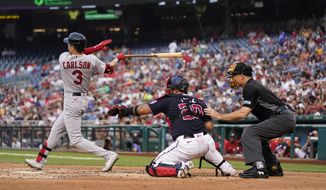 St. Louis Cardinals&#39; Dylan Carlson hits a groundout in front of Washington Nationals catcher Keibert Ruiz and umpire Dan Iassogna in the third inning of a baseball game, Friday, July 29, 2022, in Washington. Andrew Knizner scored on the play. (AP Photo/Patrick Semansky)