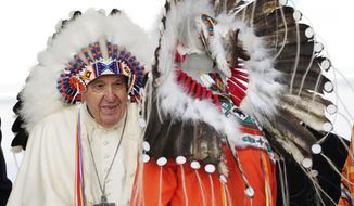 Pope Francis, left, wears a traditional headdress he was given after his apology to Indigenous people during a ceremony in Maskwacis, Alberta, as part of his papal visit across Canada, Monday, July 25, 2022. Pope Francis crisscrossed Canada this week delivering long overdue apologies to the country&#x27;s Indigenous groups for the decades of abuses and cultural destruction they suffered at Catholic Church-run residential schools. (Nathan Denette/The Canadian Press via AP)