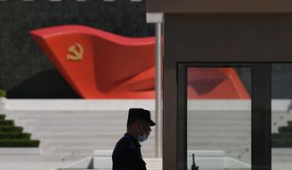 A security guard stands near a sculpture of the Chinese Communist Party flag at the Museum of the Communist Party of China on May 26, 2022, in Beijing. China said it was conducting military exercises Saturday, July 30, off its coast opposite Taiwan after warning Speaker Nancy Pelosi of the U.S. House of Representatives to scrap possible plans to visit the island democracy, which Beijing claims as part of its territory. (AP Photo/Ng Han Guan, File)