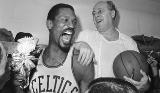 FILE - Boston Celtics&#39; Bill Russell, left, holds a corsage sent to the dressing room as he celebrates with Celtics coach Red Auerbach after defeating the Los Angeles Lakers, 95-93, to win their eighth-straight NBA Championship, in Boston, in this April 29, 1966, photo. The NBA great Bill Russell has died at age 88. His family said on social media that Russell died on Sunday, July 31, 2022. Russell anchored a Boston Celtics dynasty that won 11 titles in 13 years. (AP Photo/File)
