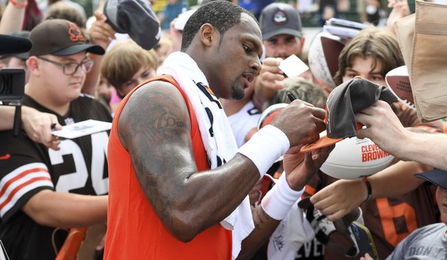 Cleveland Browns quarterback Deshaun Watson gives autographs to fans after the NFL football team&#x27;s training camp, Monday, Aug. 1, 2022, in Berea, Ohio. (AP Photo/Nick Cammett)