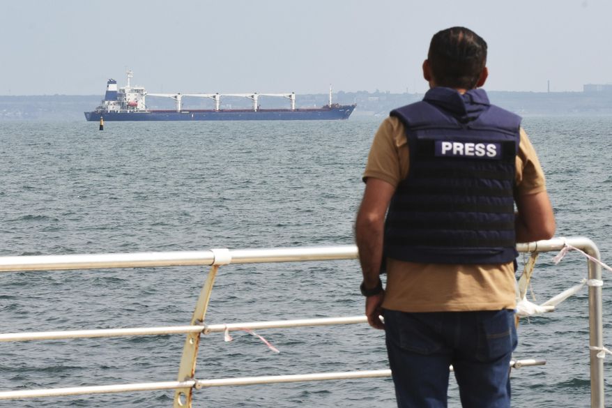 A journalist watches as the bulk carrier Razoni starts its way from the port in Odesa, Ukraine, Monday, Aug. 1, 2022. According to Ukraine&#39;s Ministry of Infrastructure, the ship under Sierra Leone&#39;s flag is carrying 26 thousand tons of Ukrainian corn to Lebanon. (AP Photo/Michael Shtekel)
