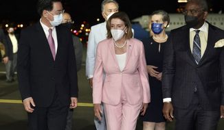 In this photo released by the Taiwan Ministry of Foreign Affairs, U.S. House Speaker Nancy Pelosi, center, walks with Taiwan&#39;s Foreign Minister Joseph Wu, left, as she arrives in Taipei, Taiwan, Tuesday, Aug. 2, 2022. Pelosi arrived in Taiwan on Tuesday night despite threats from Beijing of serious consequences, becoming the highest-ranking American official to visit the self-ruled island claimed by China in 25 years. ( Taiwan Ministry of Foreign Affairs via AP)