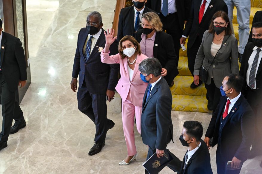 In a handout photo taken and released by Malaysia’s Department of Information, U.S. House Speaker Nancy Pelosi, center, waves to media as she tours the parliament house in Kuala Lumpur, on Tuesday, Aug. 2, 2022. (Malaysia’s Department of Information via AP)