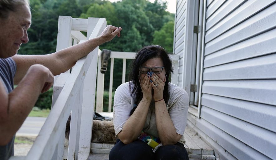 Kirsten Gomez, right, cries to her family member Kathy Hall, left, after what she calls a quiet moment to reflect on what her family has gone through in the aftermath of massive flooding, Tuesday, Aug. 2, 2022, in Hindman, Ky. (AP Photo/Brynn Anderson)