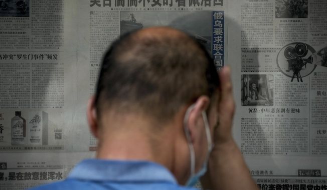 A man rubs his forehead as he reads a newspaper headline reporting &amp;quot;U.S. Taiwan staring anxiously on U.S. House Speaker Nancy Pelosi&amp;quot; at a stand in Beijing, Tuesday, Aug. 2, 2022. Pelosi arrived in Malaysia on Tuesday for the second leg of an Asian tour that has been overshadowed by an expected stop in Taiwan, which would escalate tensions with Beijing that claims the self-ruled island as its own territory. (AP Photo/Andy Wong)