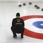 In this photo provided by Curling Jamaica, Jamaica&#39;s Ben Kong looks out at the sheet during a practice game against Hong Kong on Saturday, April 2, 2022, at the Unionville Curling Club in Markham, Ontario, Canada. The Jamaican curlers are sliding into the footsteps of the bobsledders that brought the tropical island nation to the Winter Olympics and became an international sensation. (Sandy Ewart/Curling Jamaica photo via AP)