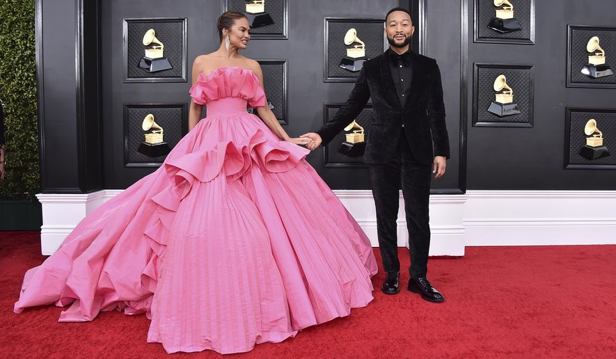Chrissy Teigen, left, and John Legend arrive at the 64th Annual Grammy Awards at the MGM Grand Garden Arena on April 3, 2022, in Las Vegas. Chrissy Teigen and her husband John Legend are expecting another child nearly two years after the couple suffered a pregnancy loss. Teigen made the announcement Wednesday, Aug. 3, 2022, on Instagram where she posted two photos of her baby bump. (Photo by Jordan Strauss/Invision/AP, File)