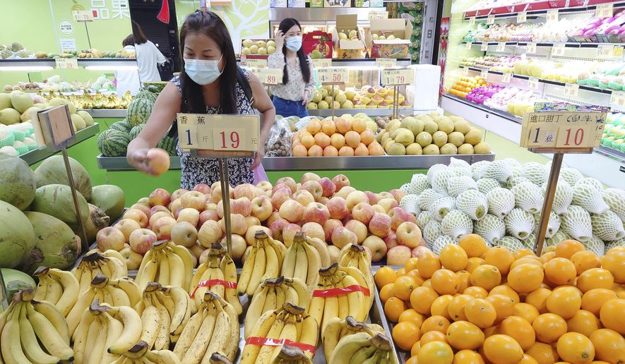 Customers buy fruit at a stall in Taipei, Taiwan, on Sept. 20, 2021. China has blocked imports of citrus and fish from Taiwan in retaliation for a visit to the self-ruled island by a top American lawmaker but avoided sanctions on Taiwanese processor chips for Chinese assemblers of smartphones and other electronics, a step that would send shockwaves through the global economy. (AP Photo/Chiang Ying-ying, File)