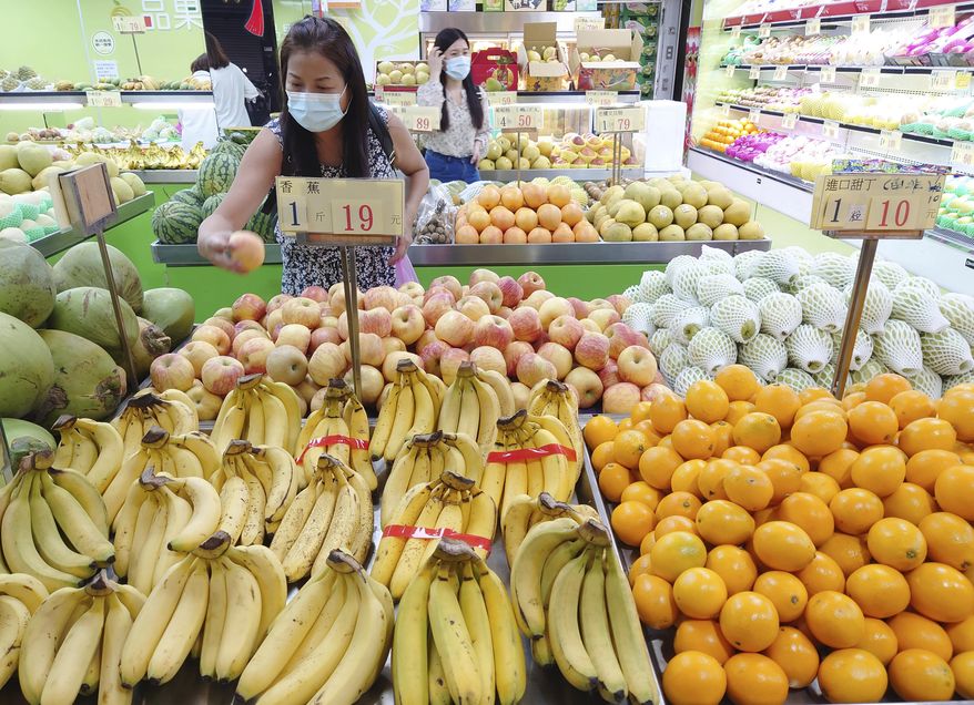 Customers buy fruit at a stall in Taipei, Taiwan, on Sept. 20, 2021. China has blocked imports of citrus and fish from Taiwan in retaliation for a visit to the self-ruled island by a top American lawmaker but avoided sanctions on Taiwanese processor chips for Chinese assemblers of smartphones and other electronics, a step that would send shockwaves through the global economy. (AP Photo/Chiang Ying-ying, File)