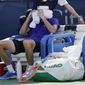 Taylor Fritz, of the United States, wraps his head is ice-cold towels between sets during a match against Daniel Evans, of Britain, at the Citi Open tennis tournament in Washington, Thursday, Aug. 4, 2022. (AP Photo/Carolyn Kaster)