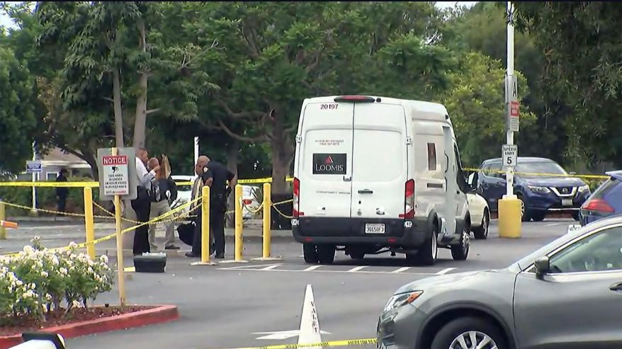 In this aerial image taken from video provided by KABC-TV law enforcement investigate an armored vehicle robbery in Gardena, Calif., on Thursday, Aug. 4, 2022. Several robbers ambushed the armored vehicle in broad daylight Thursday and opened fire on the armed guards, injuring one critically in a Southern California casino's parking lot before fleeing with cash, police said. (KABC-TV via AP)