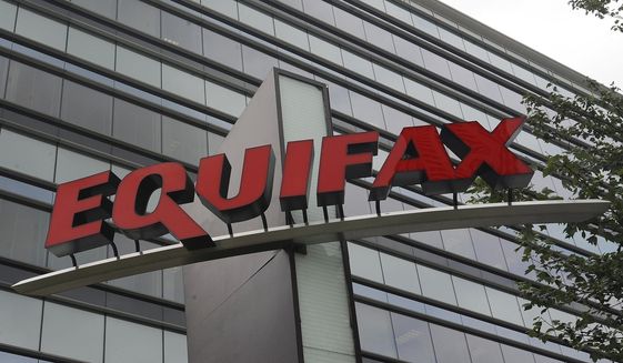FILE- This July 21, 2012, file photo shows signage at the corporate headquarters of Equifax Inc. in Atlanta. A Florida woman has sued Equifax claiming she was denied a car loan because of a 130-point mistake she says was part of a larger group of credit score errors the ratings agency made last spring due to a coding problem. The class action lawsuit was filed in federal court in Atlanta, Thursday, Aug. 4, 2022.  (AP Photo/Mike Stewart, File)