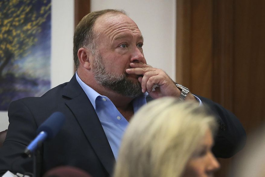 Alex Jones attempts to answer questions about his text messages asked by Mark Bankston, lawyer for Neil Heslin and Scarlett Lewis, during trial at the Travis County Courthouse in Austin, Wednesday Aug. 3, 2022. Jones testified Wednesday that he now understands it was irresponsible of him to declare the Sandy Hook Elementary School massacre a hoax and that he now believes it was “100% real.&amp;quot; (Briana Sanchez/Austin American-Statesman via AP, Pool)