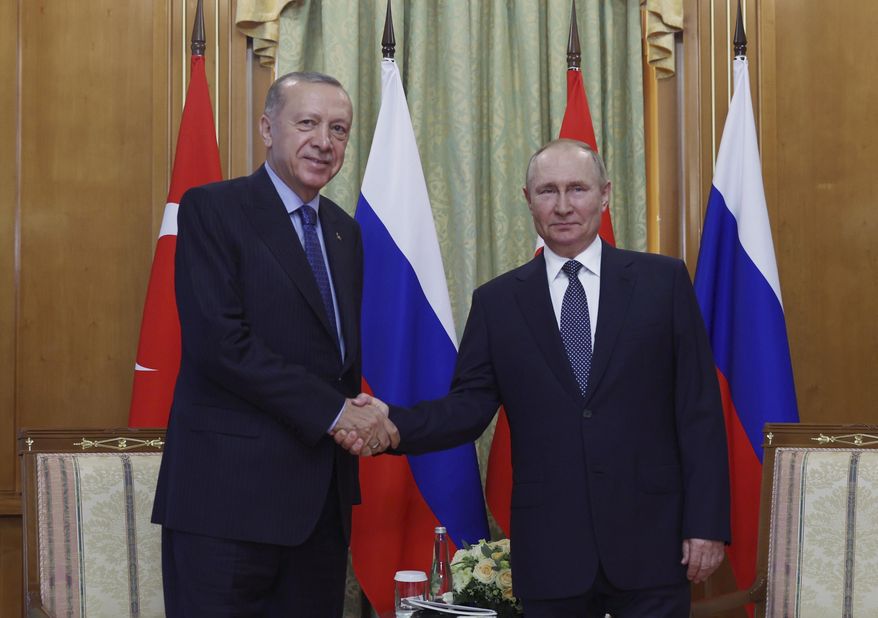 In this handout photo provided by the Turkish Presidency, Turkish President Recep Tayyip Erdogan, left, and Russian President Vladimir Putin shake hands prior to their meeting at the Rus sanatorium in the Black Sea resort of Sochi, Russia, Friday, Aug. 5, 2022.( Turkish Presidency via AP )