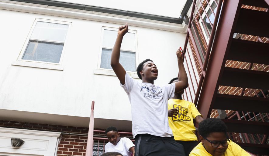 Imand Peterson, 15, takes a break with his friends during rehearsal at the Roots of Music in New Orleans, Monday, July 25, 2022. The nonprofit Roots of Music is an after-school music program that works with at-risk students between the ages of 9-14. (Sophia Germer/The Times-Picayune/The New Orleans Advocate via AP)