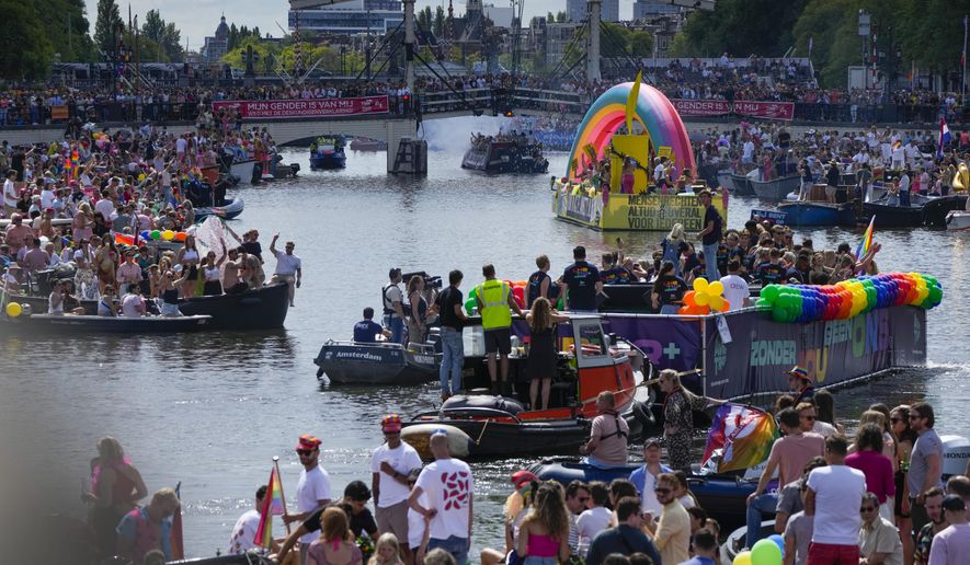 Hundreds of thousands of people lined canals in the Dutch capital to watch the colorful spectacle of the Pride Canal Parade return for the 25th edition after the last two events were canceled due to the COVID-19 pandemic, in Amsterdam, Netherlands, Saturday, Aug. 6, 2022. (AP Photo/Peter Dejong)