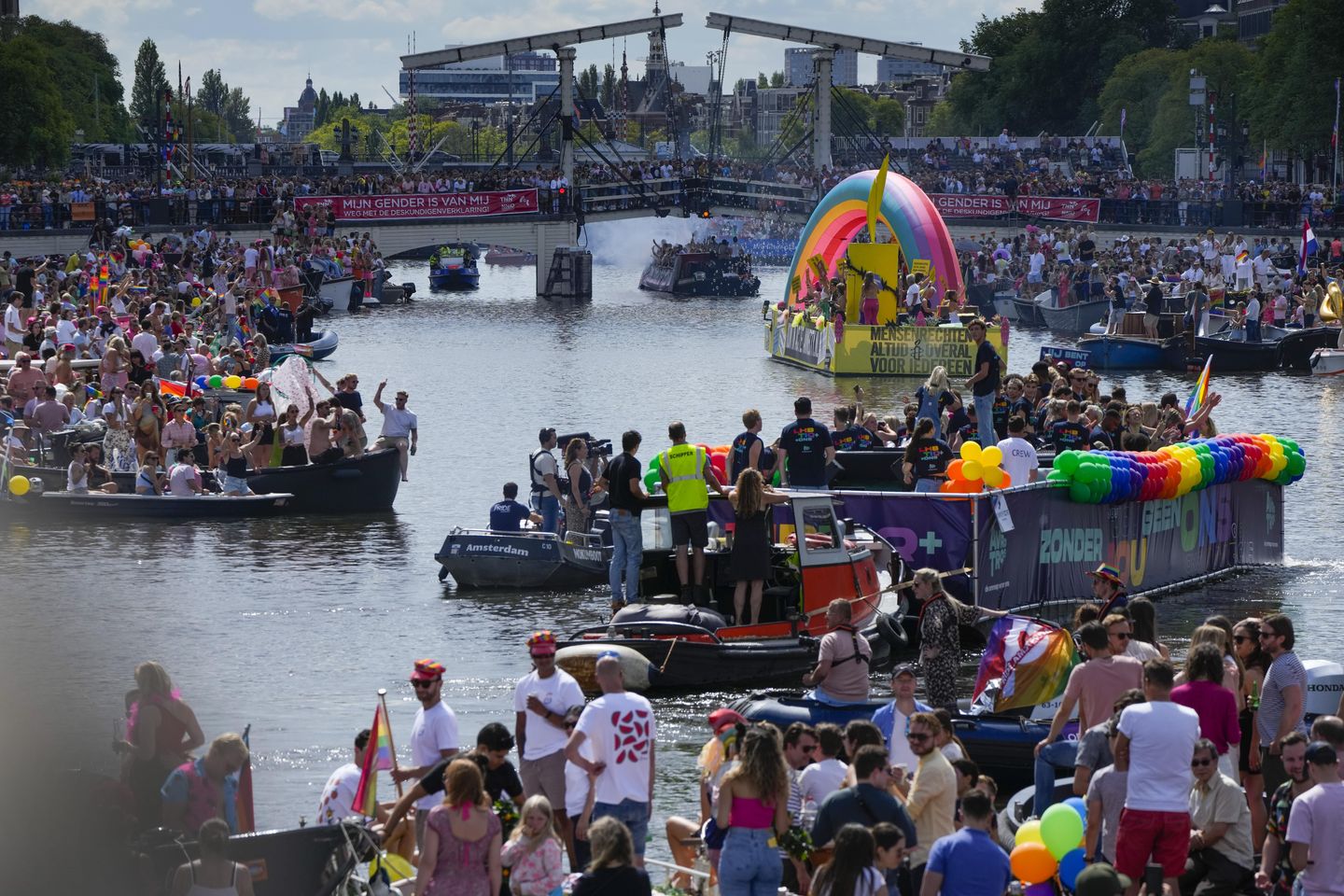 Büyük kalabalıklar Amsterdam Pride'ın kanal geçit töreni kutlamasını izliyor