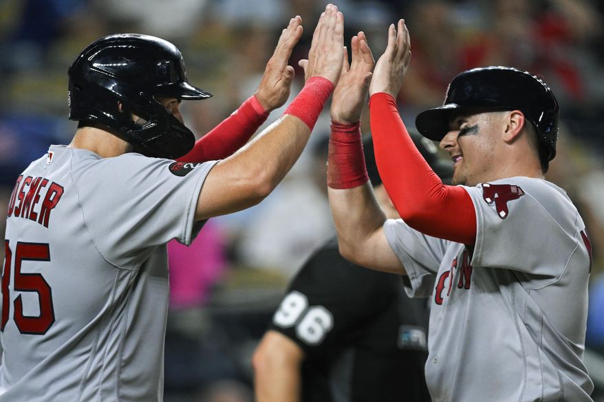 Boston Red Sox&#39;s Eric Hosmer, left, and Reese McGuire, celebrate after scoring against the Kansas City Royals on a double by Jarren Duran during the eighth inning of a baseball game Friday, Aug. 5, 2022, in Kansas City, Mo. (AP Photo/Reed Hoffmann)