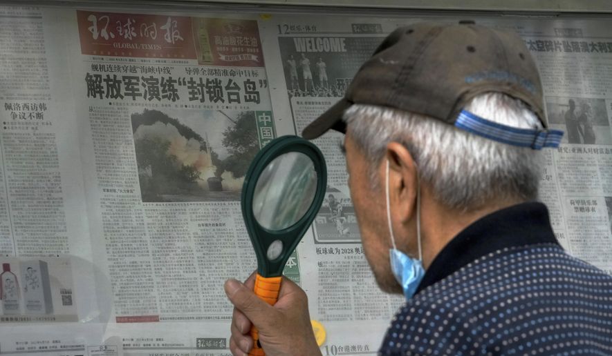 A man uses a magnifying glass to read a newspaper headline reporting on Chinese People&#x27;s Liberation Army (PLA) conducting military exercises, at a stand in Beijing, Sunday, Aug. 7, 2022. U.S. Secretary of State Antony Blinken said Saturday that China should not hold hostage talks on important global matters such as the climate crisis, after Beijing cut off contacts with Washington in retaliation for U.S. House Speaker Nancy Pelosi&#x27;s visit to Taiwan earlier this week. (AP Photo/Andy Wong)