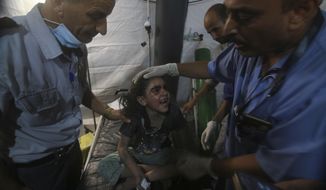 Medics treat a wounded girl at the al Najar hospital following an Israeli airstrike on their family building in Rafah, southern Gaza Strip, Saturday, Aug. 6, 2022. Israeli airstrikes have flattened homes in Gaza and Palestinian rocket barrages into southern Israel are persisting for a second day. (AP Photo/Hatem Ali)