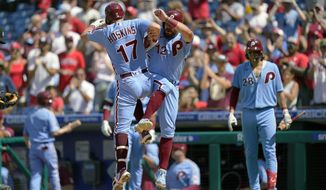 Philadelphia Phillies&#39; Rhys Hoskins (17) celebrates with Kyle Schwarber after hitting a two-run home run off of Washington Nationals relief pitcher Cory Abbott during the fourth inning of a baseball game, Sunday, Aug. 7, 2022, in Philadelphia. (AP Photo/Matt Rourke)
