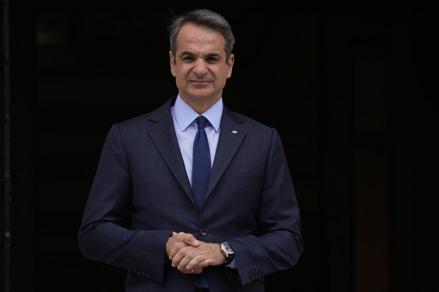 Greece's Prime Minister Kyriakos Mitsotakis stands outside Maximos Mansion in Athens, May 6, 2022. Mitsotakis insists he was unaware that the country's intelligence service had been bugging the mobile phone of an opposition politician for three months, and that had he known, he would not have allowed it. The comments came in a televised address to the nation by Mitsotakis, on Monday, Aug. 8. (AP Photo/Thanassis Stavrakis, File)