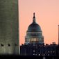 The U.S. Capitol building, center, is seen next to the bottom part of the Washington Monument, left, before sunrise on Capitol Hill in Washington, Thursday, Dec. 19, 2019. (AP Photo/Julio Cortez)