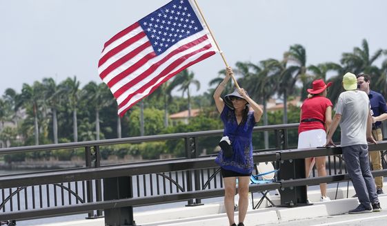 Adriane Shochet stands on a bridge outside the entrance to former President Donald Trump&#39;s Mar-a-Lago estate, Tuesday, Aug. 9, 2022, in Palm Beach, Fla. The FBI searched Trump&#39;s Mar-a-Lago estate as part of an investigation into whether he took classified records from the White House to his Florida residence, people familiar with the matter said Monday. (AP Photo/Lynne Sladky)