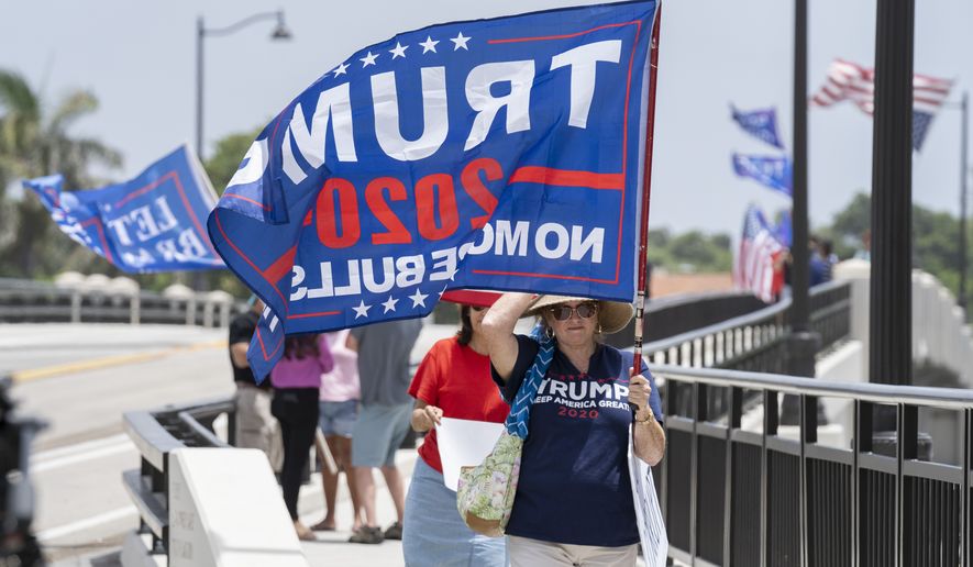 Trump supporters carry flags near Mar-a-Lago in Palm Beach, Fla., on August 9, 2022. (Greg Lovett/The Palm Beach Post via AP)