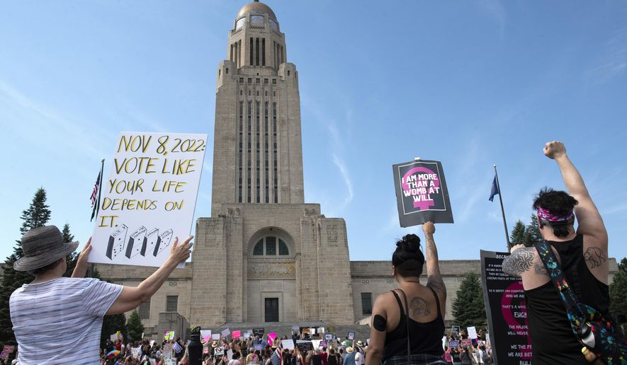 Protesters line the street around the front of the Nebraska State Capitol during an Abortion Rights Rally held on July 4, 2022, in Lincoln, Neb. A Nebraska woman has been charged in early June with helping her teenage daughter end her pregnancy at about 24 weeks after investigators uncovered Facebook messages in which the two discussed using medication to induce an abortion and plans to burn the fetus afterward. (Kenneth Ferriera/Lincoln Journal Star via AP, File)