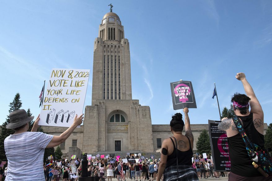 Protesters line the street around the front of the Nebraska State Capitol during an Abortion Rights Rally held on July 4, 2022, in Lincoln, Neb. A Nebraska woman has been charged in early June with helping her teenage daughter end her pregnancy at about 24 weeks after investigators uncovered Facebook messages in which the two discussed using medication to induce an abortion and plans to burn the fetus afterward. (Kenneth Ferriera/Lincoln Journal Star via AP, File)