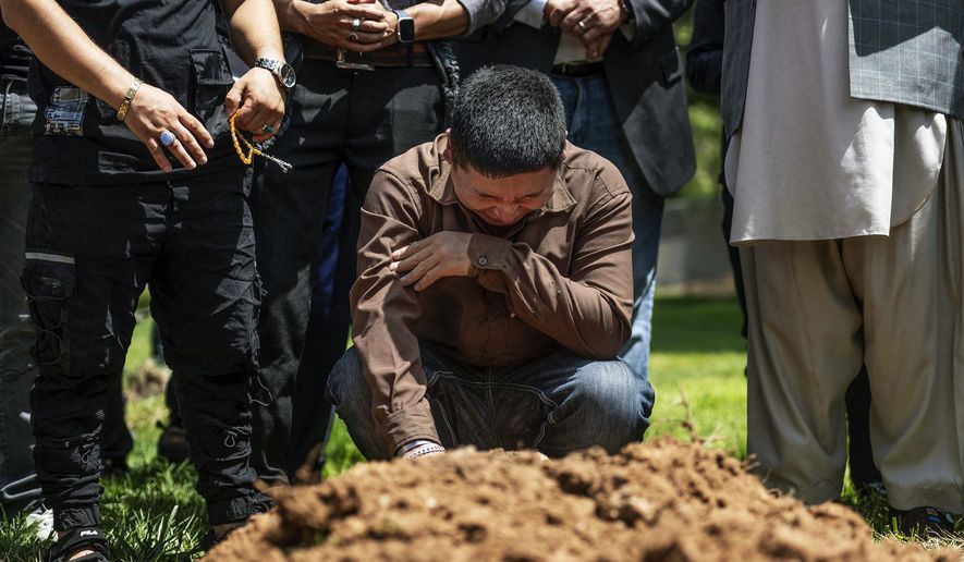 Altaf Hussain cries over the grave of his brother Aftab Hussein at Fairview Memorial Park in Albuquerque, N.M., on Friday, Aug. 5, 2022. A funeral service was held for Aftab Hussein, 41, and Muhammad Afzaal Hussain, 27, at the Islamic Center of New Mexico on Friday. Both Muslim men were shot and killed near their homes only six days apart. Law enforcement believes one suspect could be responsible for killing three Muslim men in the past nine months. (Chancey Bush/The Albuquerque Journal via AP)