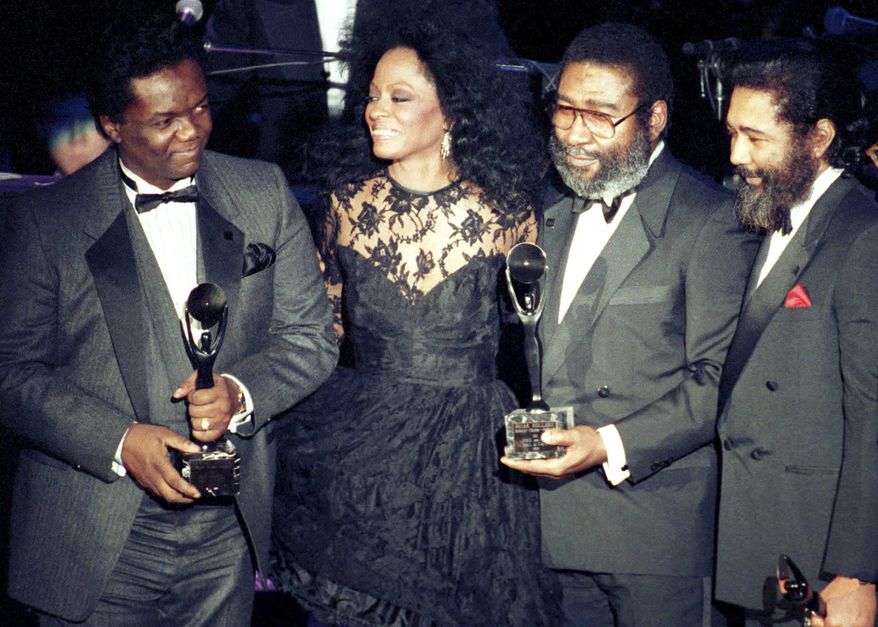 Singer Diana Ross, second from left, joins songwriters, from left, Lamont Dozier, Brian Holland and Eddie Holland after the writing team was inducted into the Rock and Roll Hall of Fame in New York on Jan. 17, 1990. Dozier, of the celebrated Holland-Dozier-Holland team that wrote and produced “You Can’t Hurry Love,” “Heat Wave” and dozens of other hits and helped make Motown an essential record company of the 1960s and beyond, has died at age 81.  (AP Photo/Ron Frehm, File)